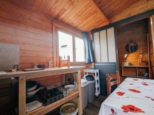 eine Küche mit Holzwänden und einem Tisch im Zimmer in der Unterkunft Cabane perchée en pleine nature, déconnexion à La Pérouille - FR-1-591-772 in La Pérouille