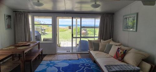 a living room with a couch and a table at Pipi Palace in Papamoa