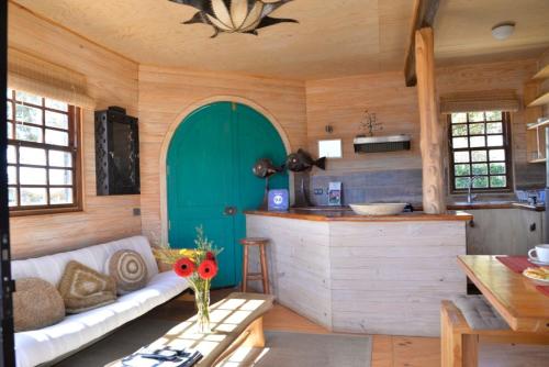 een woonkamer met een bank en een groene deur bij Hostal Sirena in Pichilemu