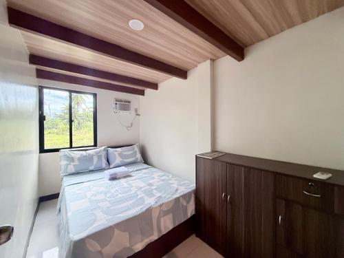 ein kleines Schlafzimmer mit einem Bett und einem Fenster in der Unterkunft Harry's Near the Beach Siargao in General Luna