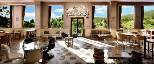 a restaurant with tables and chairs and windows at Shelter Garden Nikko in Nikko