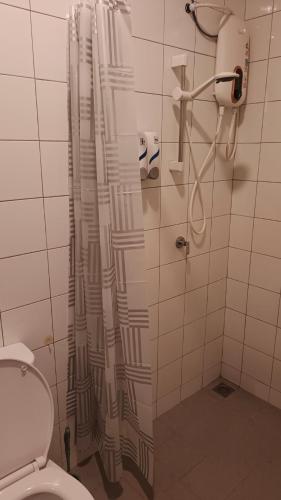 a bathroom with a shower curtain and a toilet at Alor Setar Imperio Studio by IM Staycation in Alor Setar