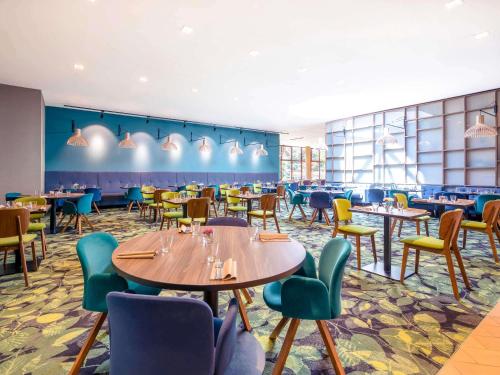 a restaurant with tables and chairs in a room at Mercure Jelenia Góra in Jelenia Góra