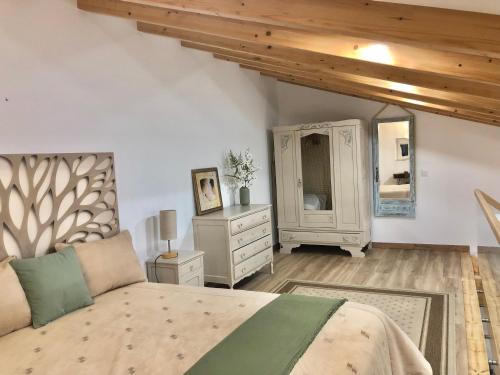 ein Schlafzimmer mit einem Bett, einer Kommode und einem Spiegel in der Unterkunft Zeca Holidays -Atalaia Fall Mezanine Ideal para trabalhar in Lourinhã