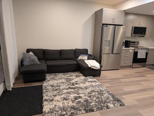 a living room with a couch and a kitchen at 21 Greenwich Common NW Calgary Alberta in Calgary