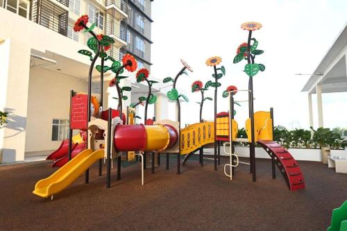 een speeltuin met een glijbaan en bloemen erop bij Sireh Residence in Kota Bharu