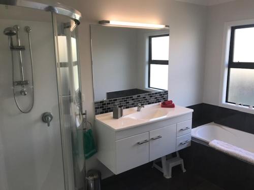 a bathroom with a sink and a shower and a tub at Parklands paradise 3bedroom4beds in Napier