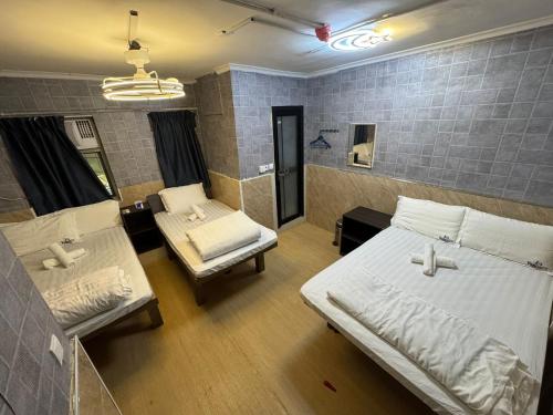 a room with two beds and two chairs in it at New Happy Land Guest House in Hong Kong