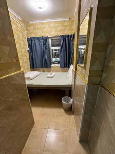 a small bathroom with a bed and a shower at Prime Star Guest House in Hong Kong