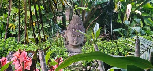 a statue in the middle of a garden at Harbour View Cottage Bay of Islands in Opua