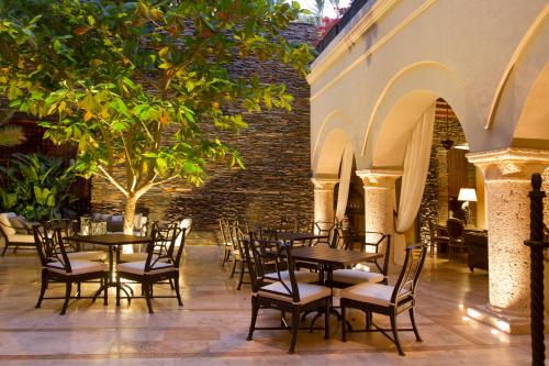 a patio with tables and chairs in a building at Bastión Luxury Hotel in Cartagena de Indias