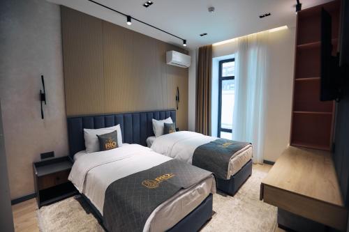 een hotelkamer met twee bedden en een raam bij RIO Hotel in Samarkand