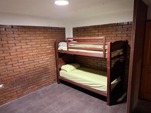 een bakstenen muur met 2 stapelbedden in een kamer bij Amplia Casa en el Centro de Arica in Arica