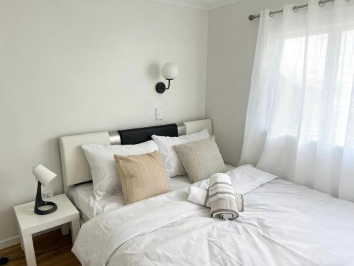 a bedroom with a white bed with a window at prime epsom in Auckland