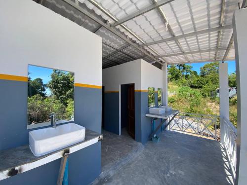 een badkamer met twee wastafels en een spiegel bij New Land Hostel in Kaôh Rŭng (3)