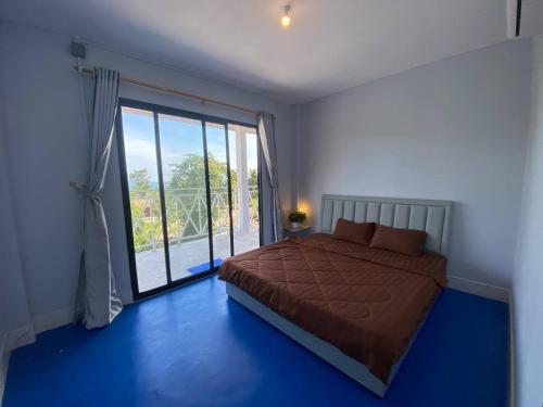 een slaapkamer met een bed en een groot raam bij New Land Hostel in Kaôh Rŭng (3)