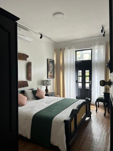 a bedroom with a large bed and a window at The Next Door in Kandy