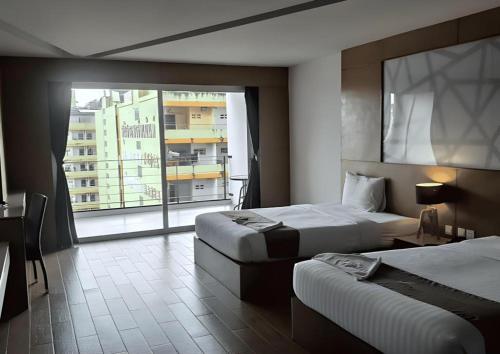 Una habitación de hotel con dos camas y una gran ventana. en The Vista Hotel By Satit Group, en Sadao