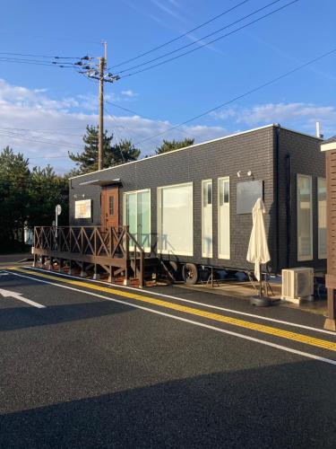 a train car parked on the side of a street at Alba HOTEL & Glamping in Nishinoura