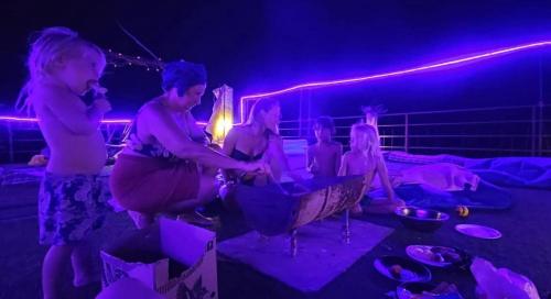 un groupe de femmes enceintes dans une pièce éclairée de lumières violettes dans l'établissement Vibe Stay by Andaz, à Arambol
