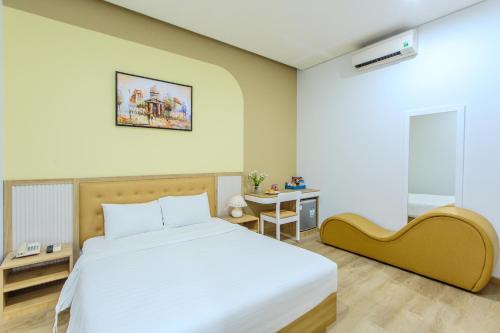 een slaapkamer met een groot bed en een tafel bij Palmier Hotel - Art House Da Nang in Da Nang