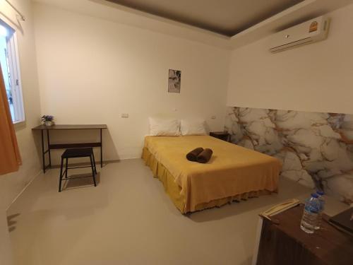 a bedroom with a bed and a table and a desk at De​ Lanta place in Ko Lanta