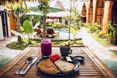 a table with a plate of bread and a drink at Corabelle Gili Air in Gili Air