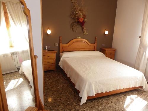 a bedroom with a large bed and a mirror at Azahara in Lloret de Mar