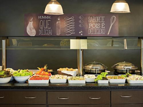 a buffet line with bowls of food on a counter at ibis Rio de Janeiro Centro in Rio de Janeiro
