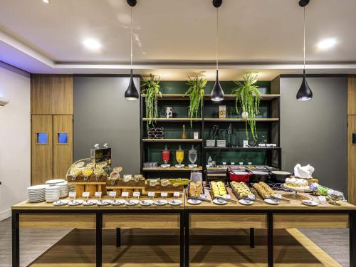 弗洛里亚诺波利斯Mercure Florianópolis的一家面包店，桌子上摆放着各种食物。