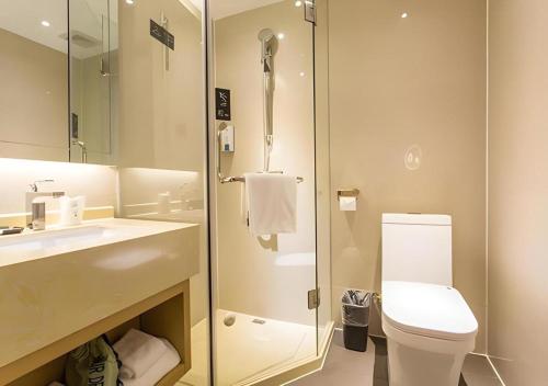 a bathroom with a toilet and a glass shower at City Comfort Inn Liuzhou Chengzhong Wanda Haiguan in Liuzhou