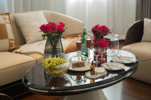 un tavolino da caffè con un vaso di rose rosse sopra di 青岛阿特拉酒店 a Qingdao