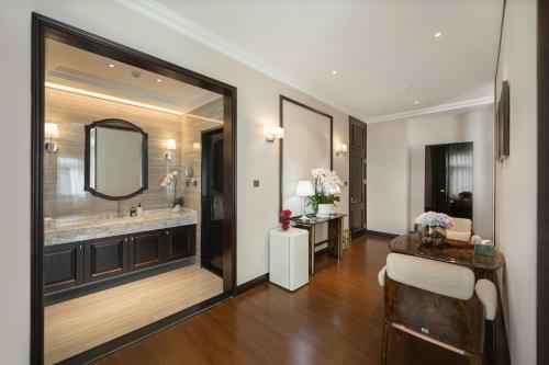 een badkamer met een grote spiegel en een wastafel bij 青岛阿特拉酒店 in Qingdao