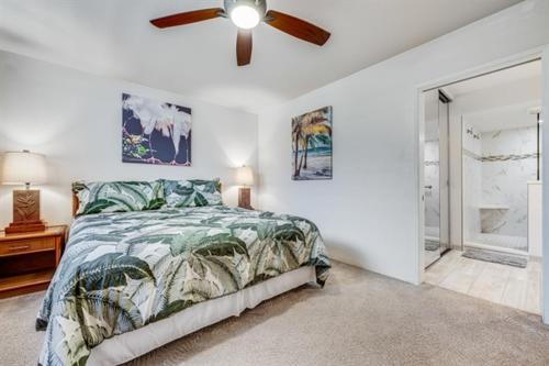 una camera da letto con un letto e un ventilatore a soffitto di Papakea Resort Unit J303 a Lahaina