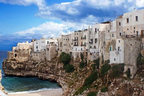 a group of buildings on a mountain next to the ocean at Bed and Breakfast Dolce Sorriso in Polignano a Mare