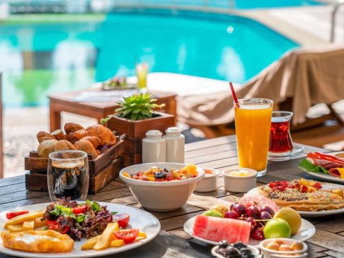 een tafel met borden en een glas sinaasappelsap bij Novotel Istanbul Zeytinburnu in Istanbul