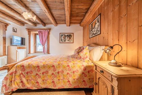 una camera da letto con un letto e un tavolo con una lampada di Da La Auri a Canale dʼAgordo