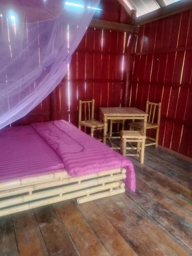 a bedroom with a bed and a table in a room at The Two Tigers - Sok San Village in Phumĭ Kaôh Rŏng