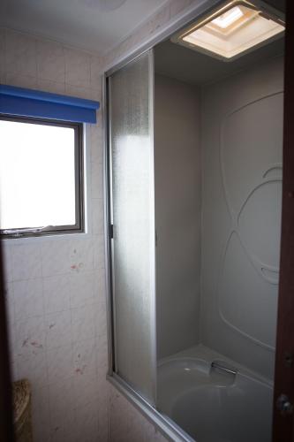 a bathroom with a shower and a bath tub at Glan Llyn Farm House in Mold