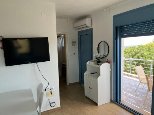 a living room with a television and a balcony at Eureka Kythira 