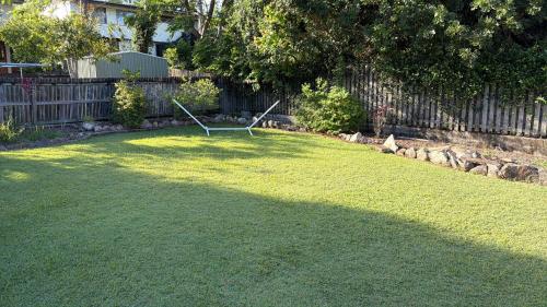 a lawn with a bench in the middle of a yard at 3BR Comfy Home, Gym & Garden in The Gap in The Gap