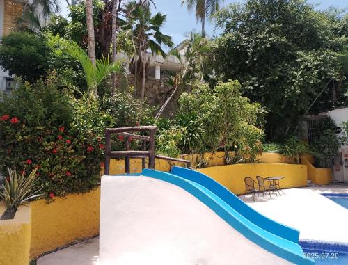 a slide in the middle of a swimming pool at Twin Towers Tres Mares in Acapulco