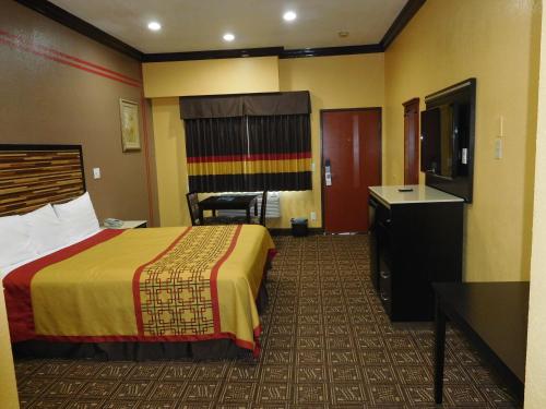 a hotel room with a bed and a flat screen tv at Diamond Inn in Inglewood