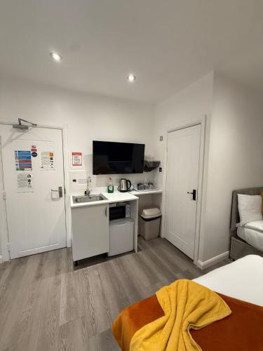 a bedroom with a bed and a kitchen with a sink at Araan House Hotel -Families and Couples Only in Blackpool