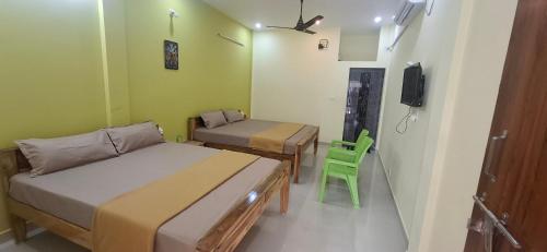 蒂鲁瓦纳马莱A J Home Stay的一间有两张床和一台电视的小房间