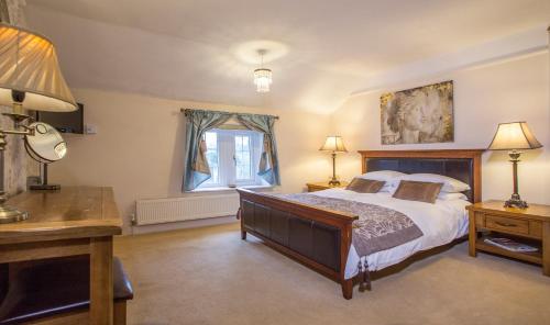 a bedroom with a bed and a desk and a window at The Old Rectory Chicklade in Chicklade