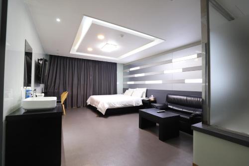 una camera da letto con un letto, un divano e un lavandino di Nampo MGM Hotel a Busan