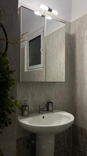 un bagno con un lavandino bianco e uno specchio di Central Oasis a Alexandroupoli