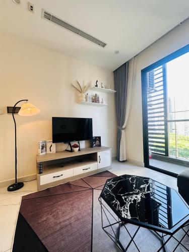 un soggiorno con televisione e tavolo di Vinhomes Grand Park the Beverly a Gò Công