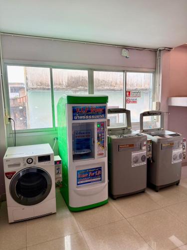 a laundry room with a washing machine and a washer at Sampheng Apartment in Bangkok